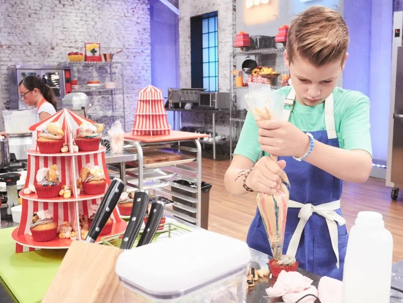 Contestant Cole Frederickson preparing his Main Heat dish, Yellow Cupcake with Deep Fried Chocolate Sandwich Cookies and Root Beer Buttercream, with the Cotton Candy Carnival Treat, as seen on Food Network's Kids Baking Championship, Season 3.