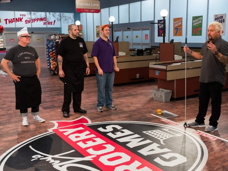 Contestants Zane Caplansky, Jon Taub and Adam Gold with Host Guy Fieri discuss the rules to Sliders, as seen on Food Network's Guy's Grocery Games, Season 12.