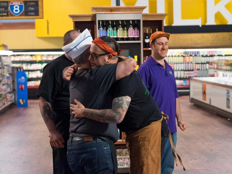 Contestant Marcus Christiana-Beniger hugs and says goodbye to Zane Caplansky, as seen on Food Network's Guy's Grocery Games, Season 12.