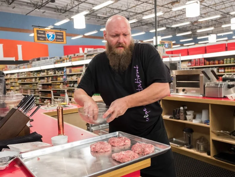 Contestant Louie Finnan makes hamburgers, as seen on Food Network's Guy's Grocery Games, Season 12.