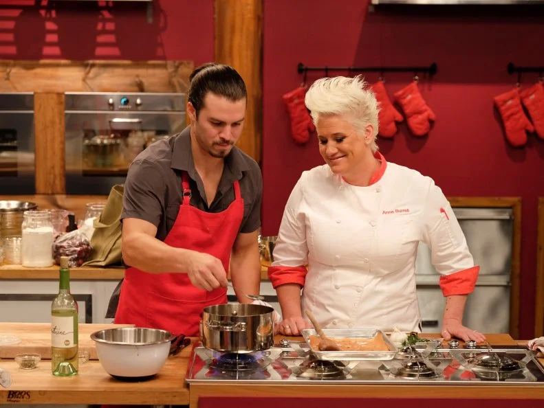 Host, Anne Burrell works with finalist, Nick Slater on a menu of goat cheese stuffed fried zucchini blossoms with zucchini noodles; stuffed rabbit loin with chanterelles, fava beans and soft polenta;  cherry crostata with vanilla ice cream, as seen on Food Network’s Worst Cooks In America, Season 8.