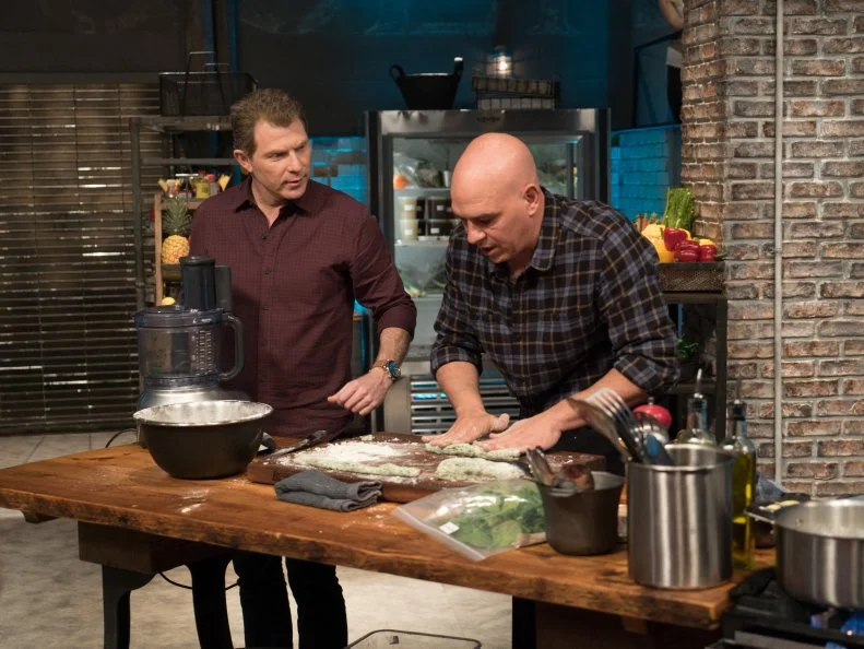 Host Bobby Flay checks in on contestant Michael Symon as he races to finish his Round 1 spinach dish, as seen on Food Network's Beat Bobby Flay, Season 8.