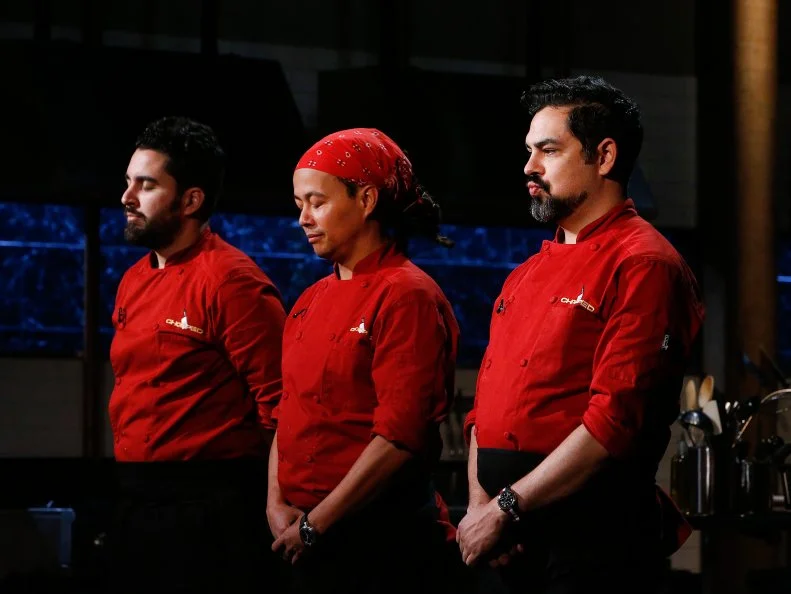 From left, chefs Meny Vaknin, Elderoy Arendse and Daniel Sharp react as Sharp is chopped during the entree round chopping, as seen on Food Network's Chopped, Season 28.