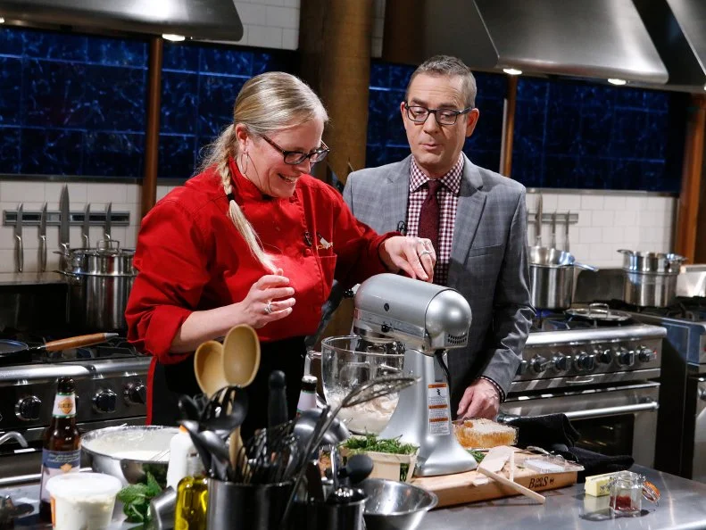 Host Ted Allen checks in on chef Jackie Sappington as she cooks with duck mousse, sea beans, saffron and honey comb during the dessert round, as seen on Food Network's Chopped, Season 28.