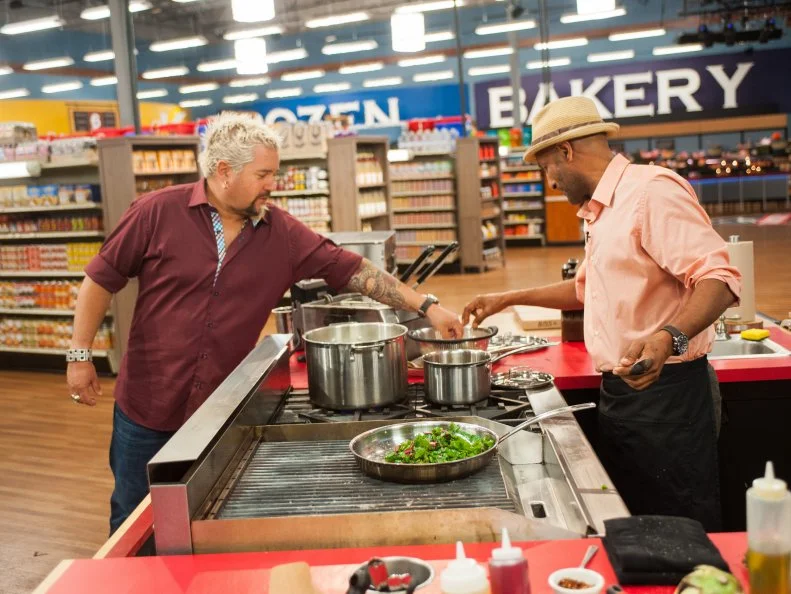 Host Guy Fieri samples some of contestant Eskender Aseged's dish, as seen on Food Network's Guy's Grocery Games, Season 9.