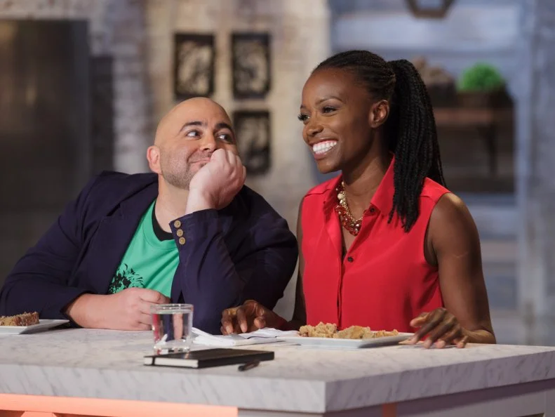 Judge Duff Goldman, left, jokes with judge Lorraine Pascale, right, as Pascale comments on an all spice cake prepared by William Poole (not pictured) during the "Berry Naked Cake" main-heat challenge, as seen on Food Network's Spring Baking Championship, Season 2.