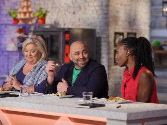 Judges, seated from left, Nancy Fuller, Duff Goldman, and Lorraine Pascale critique an almond cake prepared by Susana Mijares during the "Berry Naked Cake" main-heat challenge, as seen on Food Network's Spring Baking Championship, Season 2.