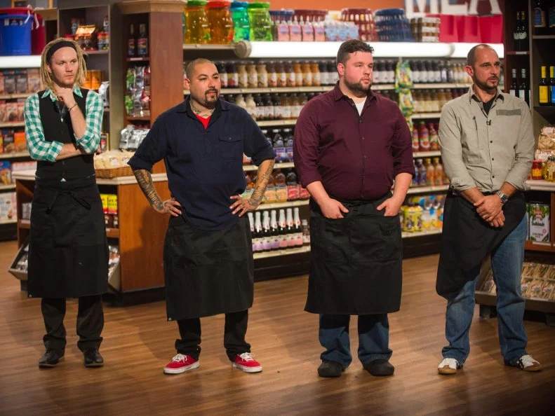 Contestant Chase Meneely, Chris Tzorin, Robbie Jester and Stephane Meloni listen as the judges critique their dishes, as seen on Food Network's Guy's Grocery Games, Season 9.