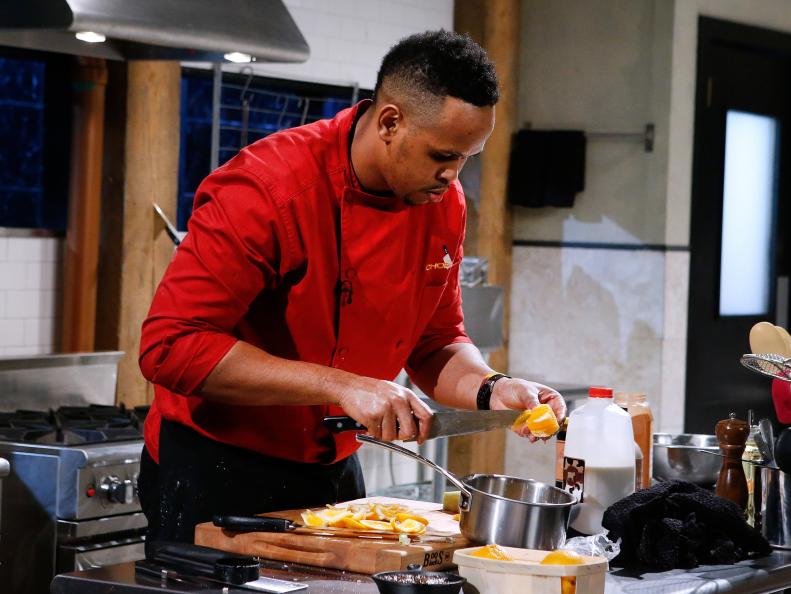 Chef Andre Fowles cooks with chocoflan, satsuma mandarin, smoked almonds and caramelized onions during the dessert round, as seen on Food Network's Chopped, Season 28.