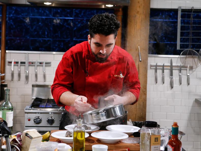 Chef Meny Vaknin cooks with mangalitsa pork burgers, chow mein noodles, tardivo and blood clams during the appetizer round, as seen on Food Network's Chopped, Season 28.