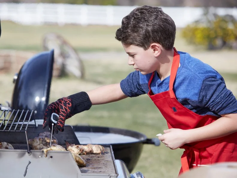 Contestant Tyler Zager prepares his dish for the Chicken BBQ Challenge, as seen on Food Network’s Kids BBQ Challenge Season 1.