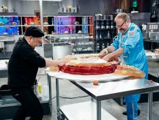 Host Alton Brown and Judge Jet Tila show off sabotage tool, Jello Basket, as seen on Food Network’s Cutthroat Kitchen, Season 13.