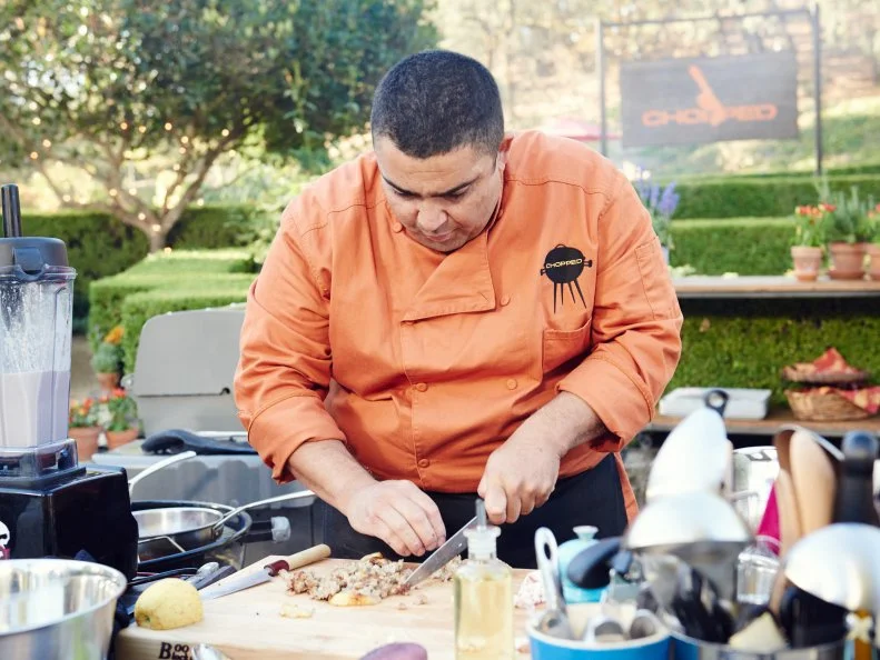 Chef Bryan Moscatello preparing his Round 1 dish, Charred Octopus with Italian Sausage Octopus Salad with Fruit Pop Dressing, Pureed Grilled Cauliflower & Sausage Sauce with Fresh Apple, as seen on Food Network's Chopped, Grill Masters Special.