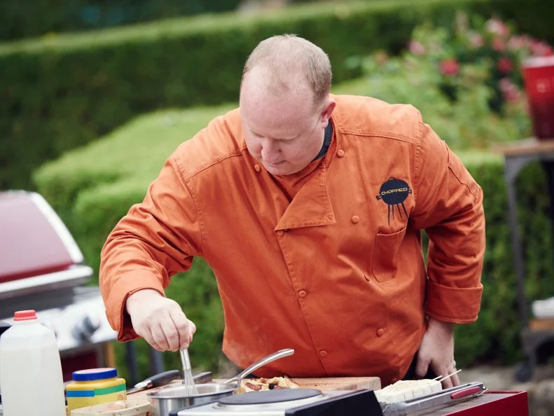 Chef Christopher Schobel preparing his dish for Round 3, Dessert Stew (Tamarind Cream Sauce Base with Cinnamon Bun Dumpling & Grilled Nutmeg Ginger Marshmallow and Strawberry Raspberry Coolie), as seen on Food Network's Chopped, Grill Masters Special.
