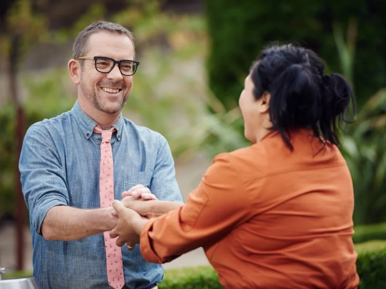 Host Ted Allen congratulating Chef Sophina Uong during Round 3 deliberation, as seen on Food Network's Chopped, Grill Masters Special.