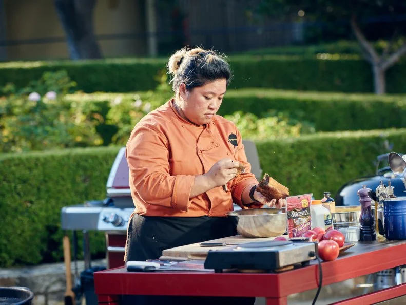 Chef Chrissy Camba preparing her Round 3 dish, Olive Oil and Cheese Bread Pudding with Brown Sugar Whisky Sauce, Sautéed and Grilled Apples and a Cheddar Crispy with Candied Walnuts, as seen on Food Network's Chopped, Grill Masters Special.