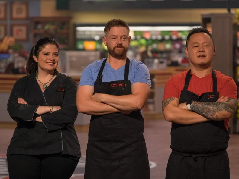 Contestant Alex Guarnaschelli, Richard Blais and Jet Tila listen to judges critique a dish, as seen on Food Network's Guy's Grocery Games, Season 10.