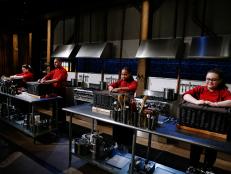 From left, host Ted Allen looks on as teen chefs Eliana de Las Casas, Gabriel Chirinos, Lyanna Cintron and Kamryn Kohler open their baskets before the appetizer round, as seen on Food Network's Chopped, Season 29.