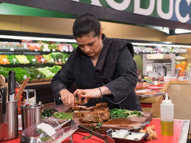 Contestant Alex Guarnaschelli separates pork, as seen on Food Network's Guy's Grocery Games, Season 10.