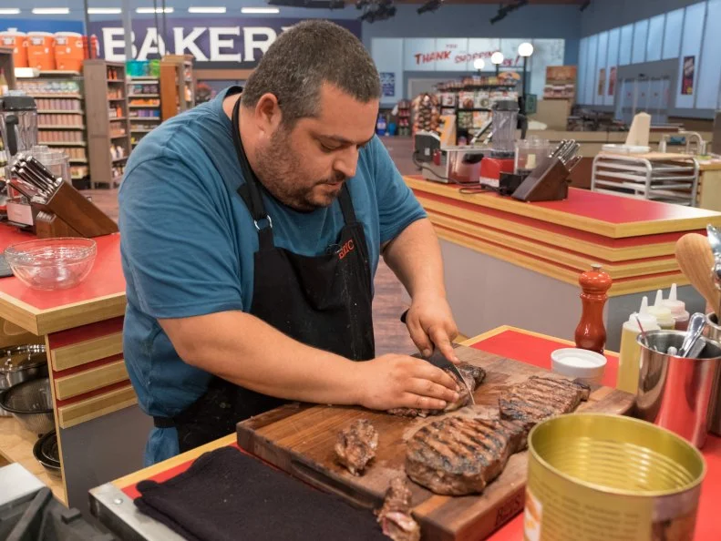 Contestant Eric Greenspan slices steaks, as seen on Food Network's Guy's Grocery Games, Season 10.