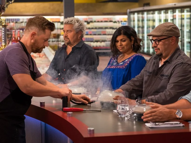 Contestant Richard Blais provides table service to judges Aarti Sequeira, Carl Ruiz and Troy Johnson, as seen on Food Network's Guy's Grocery Games, Season 10.