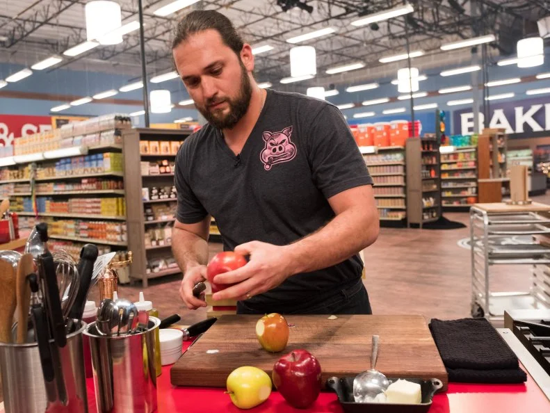 Contestant Andres Barrientos peels apples, as seen on Food Network's Guy's Grocery Games, Season 12.