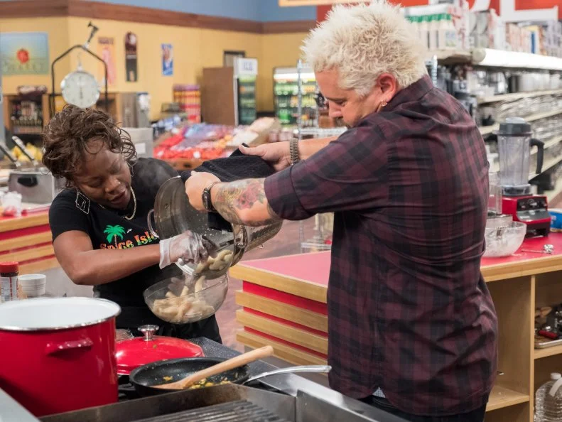 Host Guy Fieri checks in on contestant Claudette Hutchinson, as seen on Food Network's Guy's Grocery Games, Season 12.