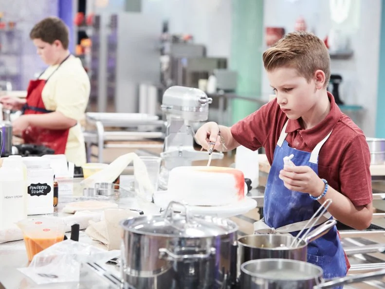 Contestant Cole Frederickson preparing his Main Heat dish, White Tie Dye Cake with Vanilla Buttercream and Airbrushed Fondant and Strawberry, Mango and Passion Fruit Swirl Ice Cream, as seen on Food Network's Kids Baking Championship, Season 3.