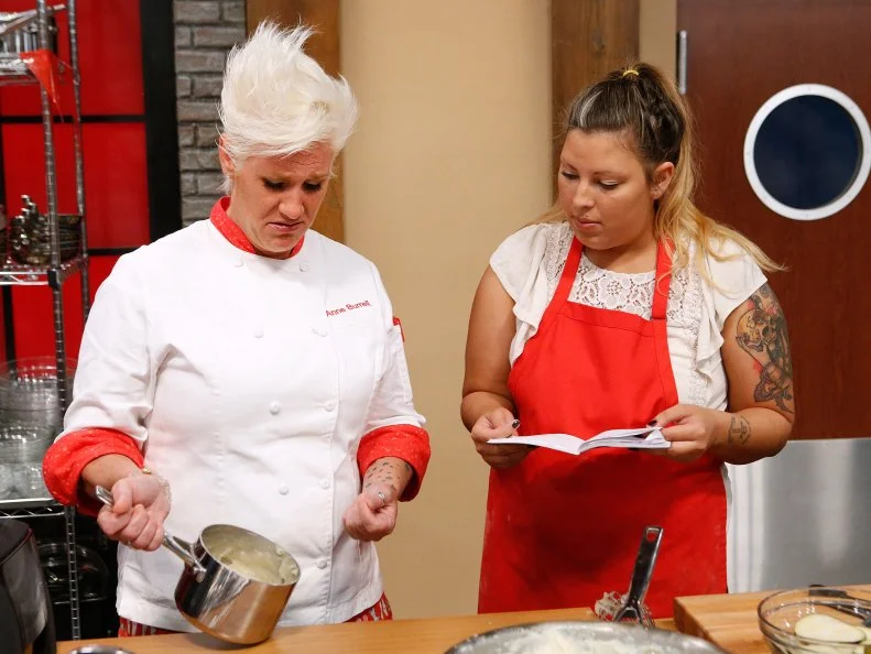 Mentor Anne Burrell checks in on Kayla Kurtz of the red team as she cooks during the main dish challenge, as seen on Food Network's Worst Cooks in America, Season 10.