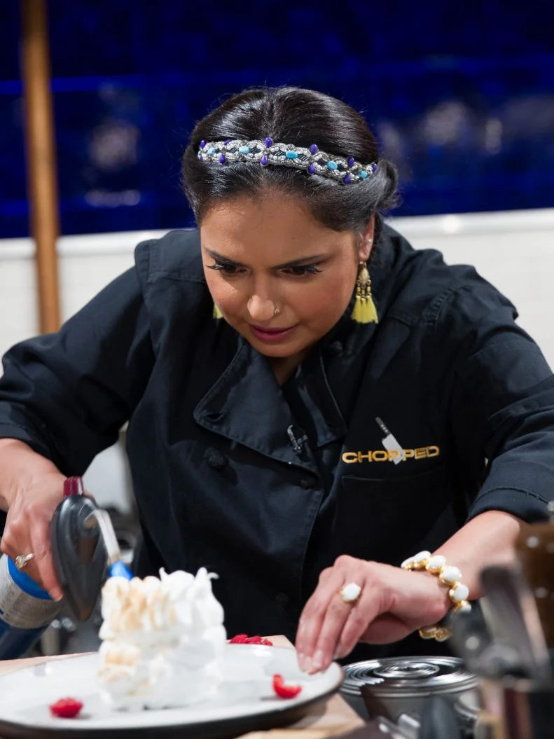 Judge Maneet Chauhan cooks Baked Alaska with apricot coulis during the dessert round, Chocolate, as seen on Food Network's Chopped After Hours, Season 32.