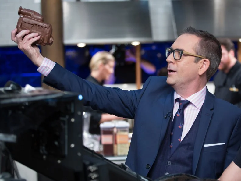 Host Ted Allen with a chocolate shaped camera during the dessert round, Chocolate, as seen on Food Network's Chopped After Hours, Season 32.