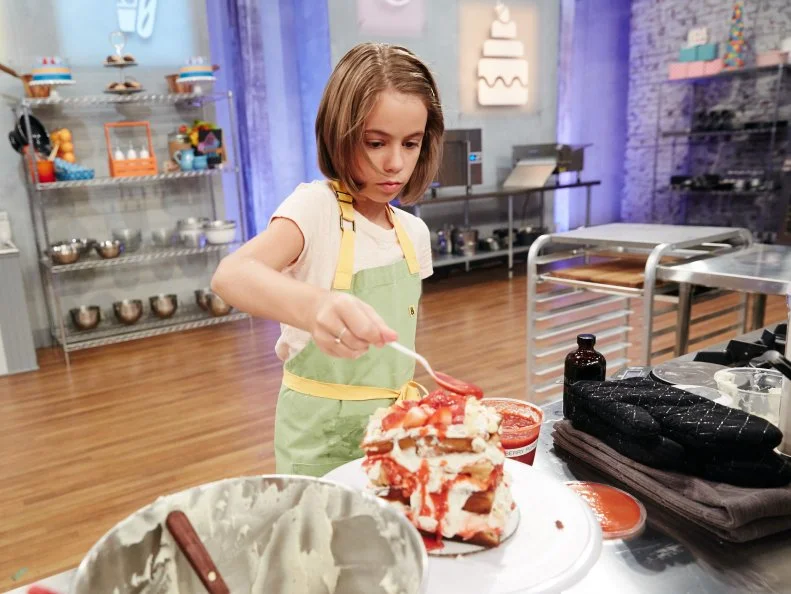 Contestant Audra Tow preparing her Main Heat dish, Strawberry Cheesecake Waffle Cake with Cream Cheese Frosting, Corn Cereal and Strawberry Puree, as seen on Food Network's Kids Baking Championship, Season 3.
