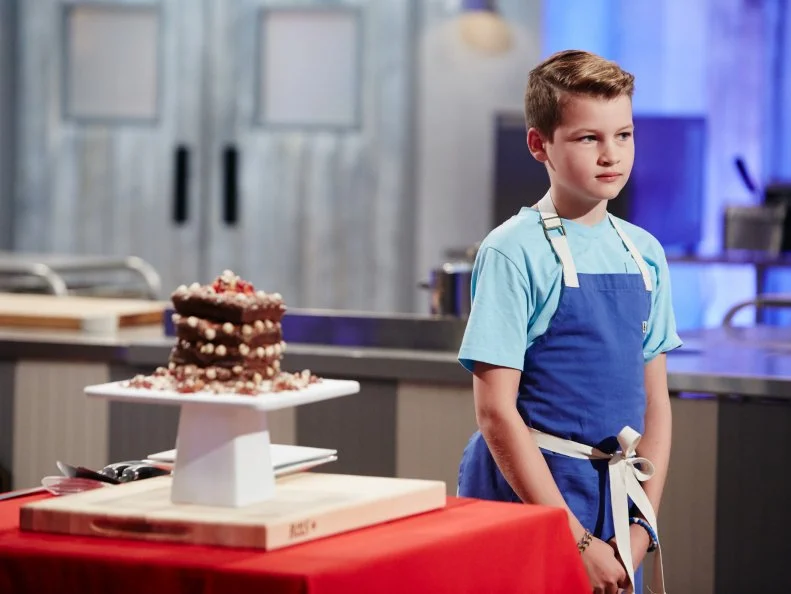 Contestant Cole Frederickson presenting his Main Chocolate Cinnamon Waffle Cake, with Chocolate Strawberry Buttercream, Hazelnut Spread, and Bacon, as seen on Food Network's Kids Baking Championship, Season 3.