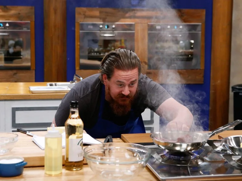 Adam Cooke of the blue team cooks during the main dish challenge, as seen on Food Network's Worst Cooks in America, Season 10.