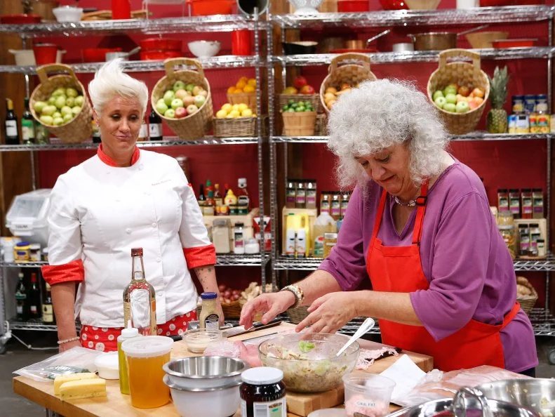 Mentor Anne Burrell checks in on Kayla Kurtz of the red team as she cooks during the main dish challenge, as seen on Food Network's Worst Cooks in America, Season 10.