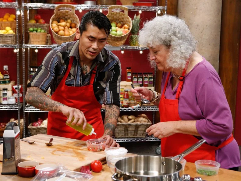 Daniel Mar and Jetta Ostrofsky of the red team cook together during the skill drill challenge, as seen on Food Network's Worst Cooks in America, Season 10.