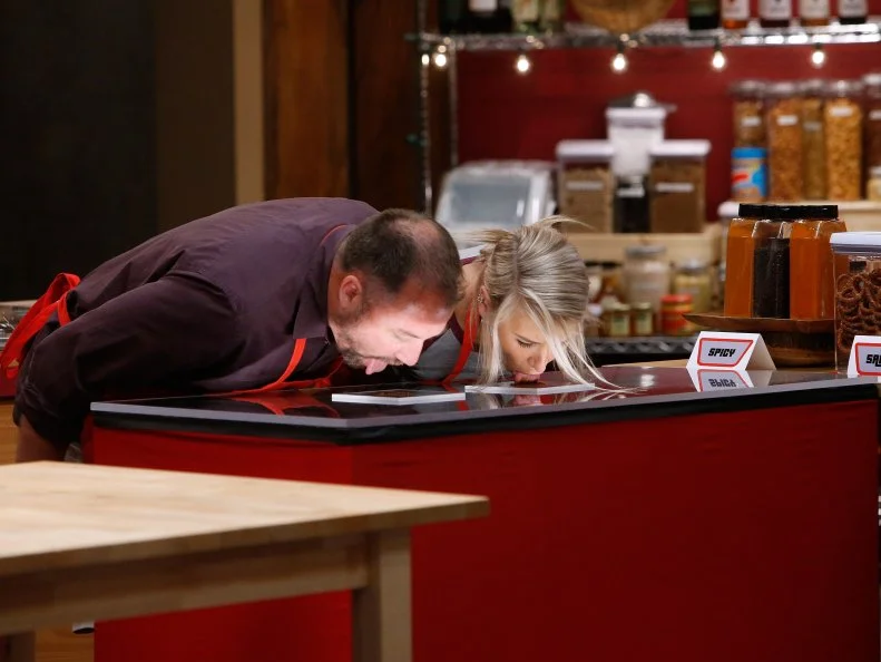 Jeff West and Mandy Thornton of the red team compete in a game of Lick It to Win It, as seen on Food Network's Worst Cooks in America, Season 10.
