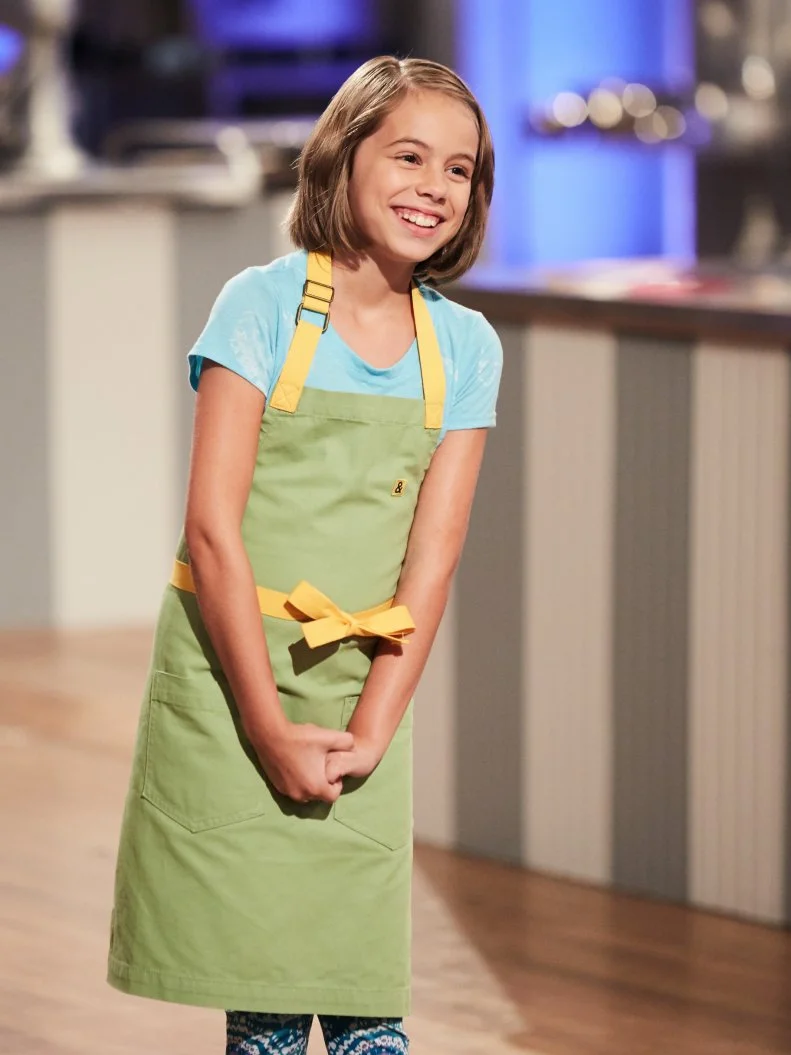 Contestant Audra Tow presenting her Main Heat dish, Lemon Sugar Cookie with Vanilla Buttercream Frosting, in the shape of Apps Dessert Craft, Pastry Chef Go, and Clash of Carbs, to Hosts Duff Goldman and Valerie Bertinelli, as seen on Food Network's Kids Baking Championship, Season 3.