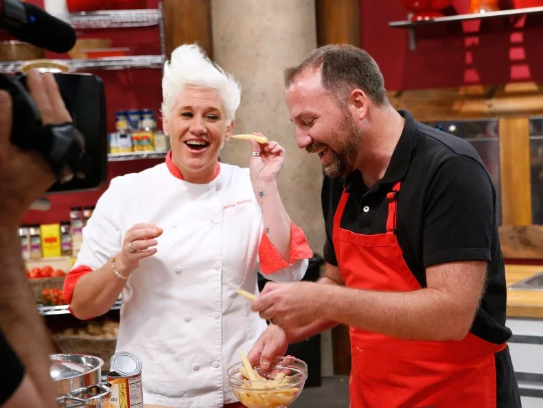 Mentor Anne Burrell pokes fun at Jeff West of the red team for having a fear of baby corn as he cooks during the skill drill challenge, as seen on Food Network's Worst Cooks in America, Season 10.