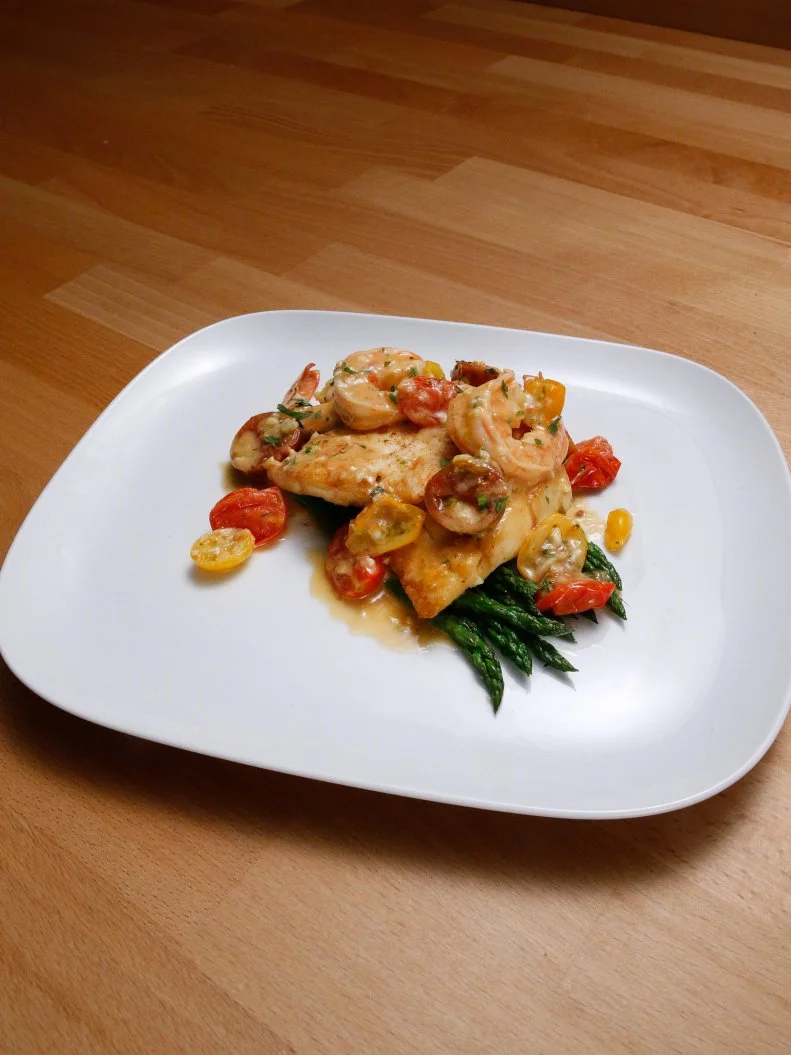 Mentor Anne Burrell's Pan Fried Flounder in Shrimp and Heirloom Tomato Pan Sauce with Pencil Asparagus dish is displayed, as seen on Food Network's Worst Cooks in America, Season 10.