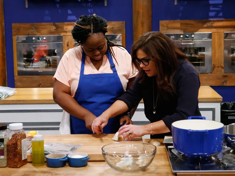 Mentor Rachael Ray helps Ann Odogwu of the blue team as she cooks during the main dish challenge, as seen on Food Network's Worst Cooks in America, Season 10.