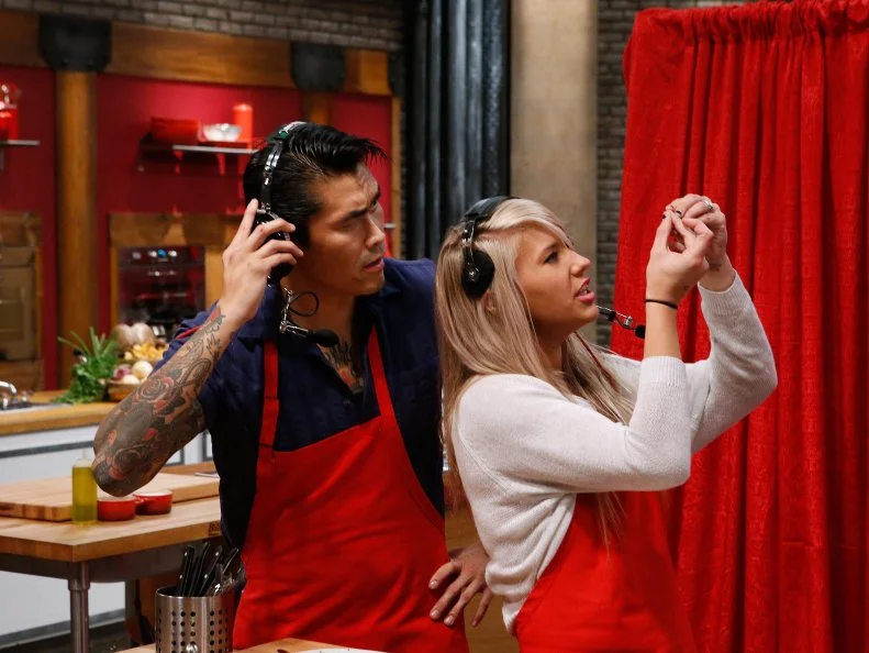 Daniel Mar and Mandy Thornton of the red team guide mentor Anne Burrell through the preparation of a dish via headset only during a game of Remote Control Chef, as seen on Food Network's Worst Cooks in America, Season 10.
