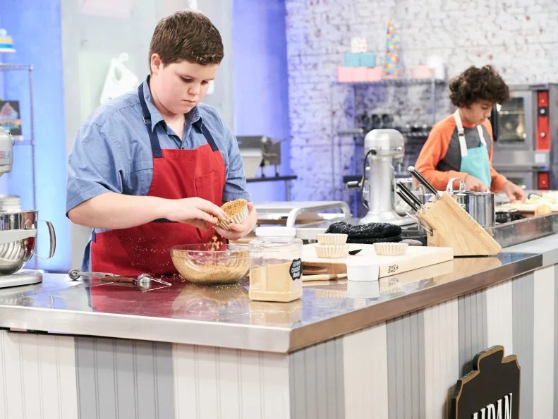 Contestant Aidan Berry preparing his dish for the Main Heat, Deconstructed Graham Cracker Tart with Smoked Chocolate Ganache, Whipped Cream, Toasted Meringue and Peanut Butter Snow, as seen on Food Network's Kids Baking Championship, Season 3.