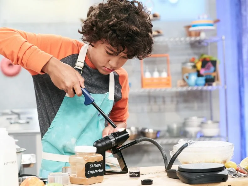 Contestant Justice Faustina preparing his Main Heat dish, Immersion Circulator Apple Cobbler with Smoked Apple Ice Cream and Whipped Cream, as seen on Food Network's Kids Baking Championship, Season 3.