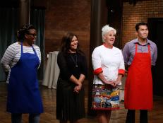 Blue team finalist Ann Odogwu stands with mentor Rachael Ray and red team finalist Daniel Mar stands with mentor Anne Burrell as they listen to feedback from the guest judges, as seen on Food Network's Worst Cooks in America, Season 10.