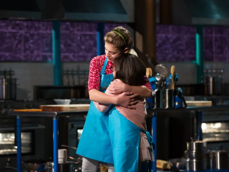 Junior contestants Nicole Bidun (L), and Olivia Acosta react as Olivia Acosta is chopped during the judging of the dessert round, as seen on Food Network's Chopped Junior, Season 6.