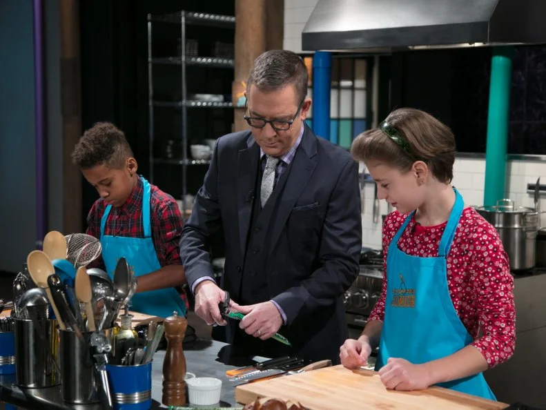 Junior contestants Tyler Casanova-Rodriguez (L) cooks as Host Ted Allen helps Nicole Bidun, as seen on Food Network's Chopped Junior, Season 6.