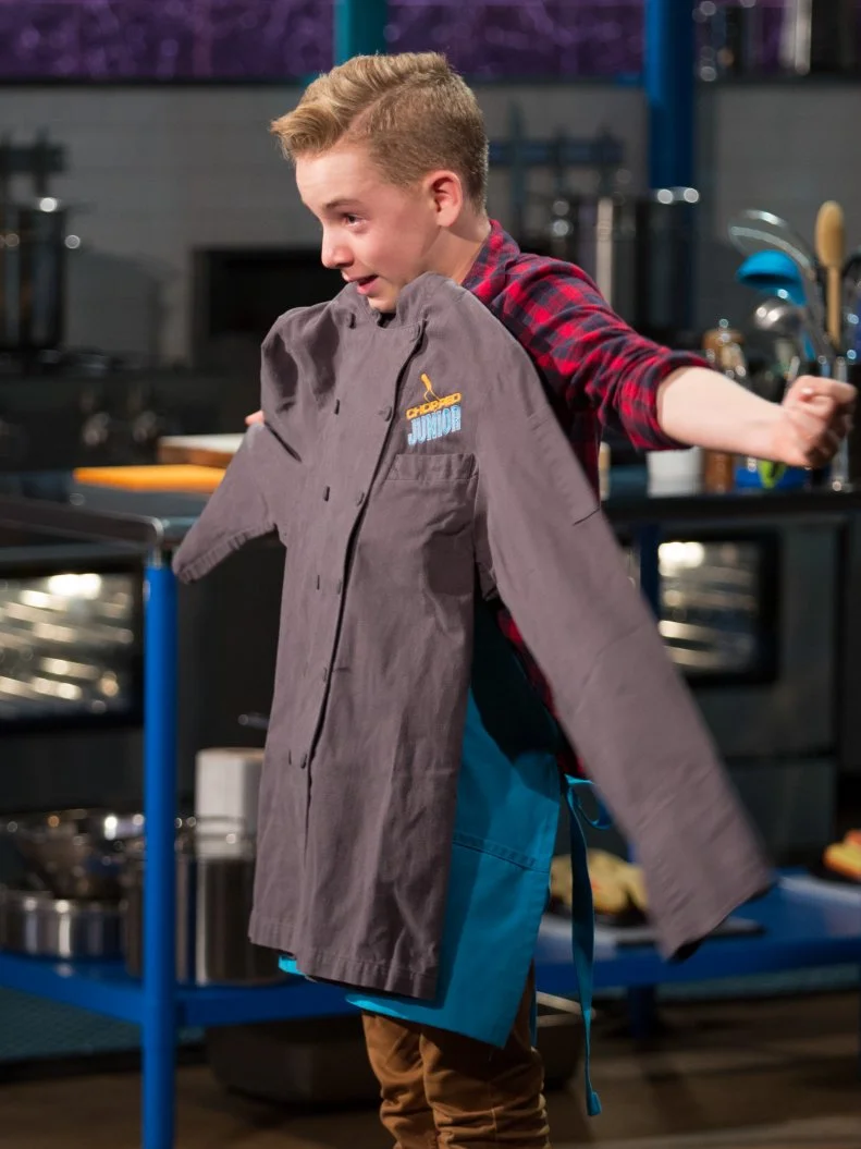 The winning Junior contestant Joshua Altamura with his  Chopped Junior Chef's coat during the judging of the dessert round, as seen on Food Network's Chopped Junior, Season 6.