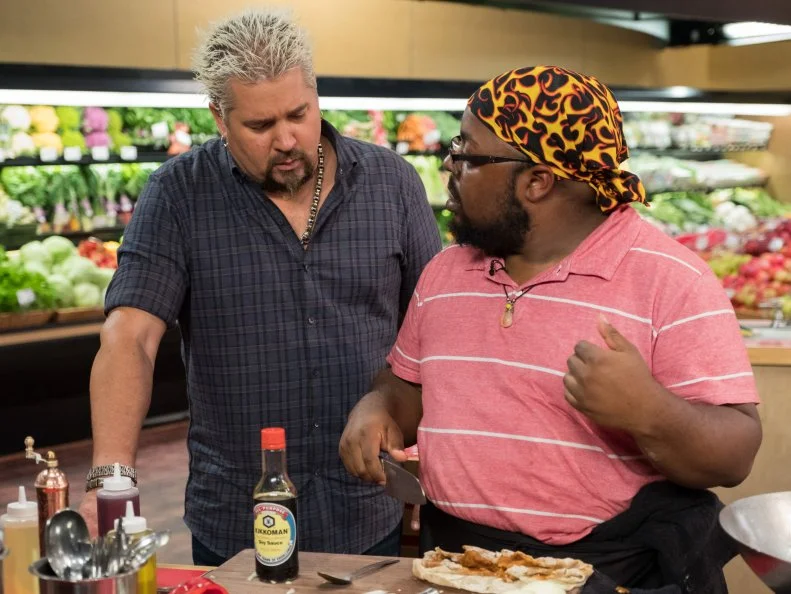 Host Guy Fieri checks in on Contestant Michael Marina, as seen on Food Network's Guy's Grocery Games, Season 12.