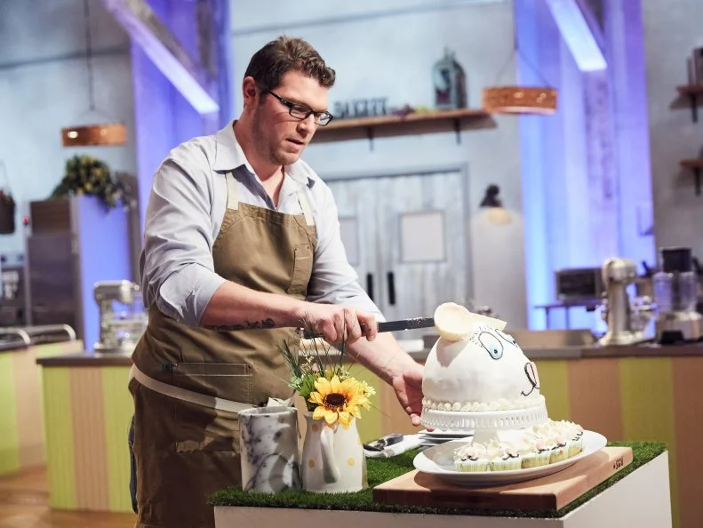 Chef Adam Young with his Main Heat dish, Citrus Cake and Cupcakes with Pistachio Praline and Berries, during judging, as seen on Food Network's Spring Baking Championship, Season 3.